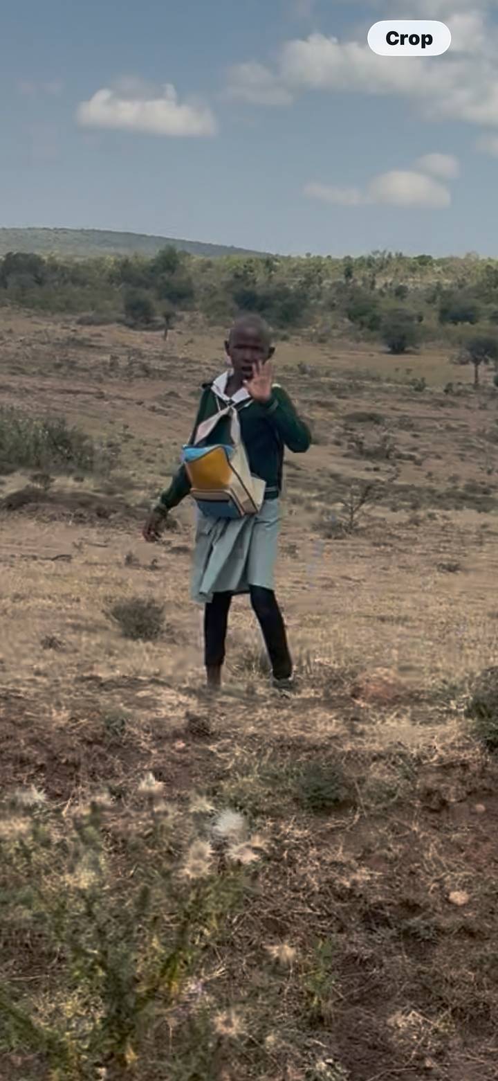 Blurry image of a person walking through arid terrain carrying a backpack.