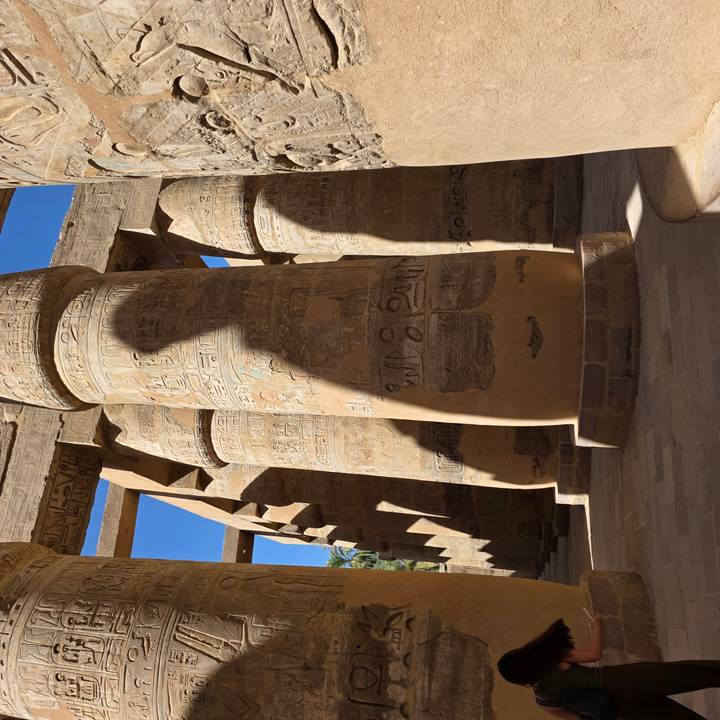 Massive engraved columns at Karnak casting deep shadows in strong sunlight