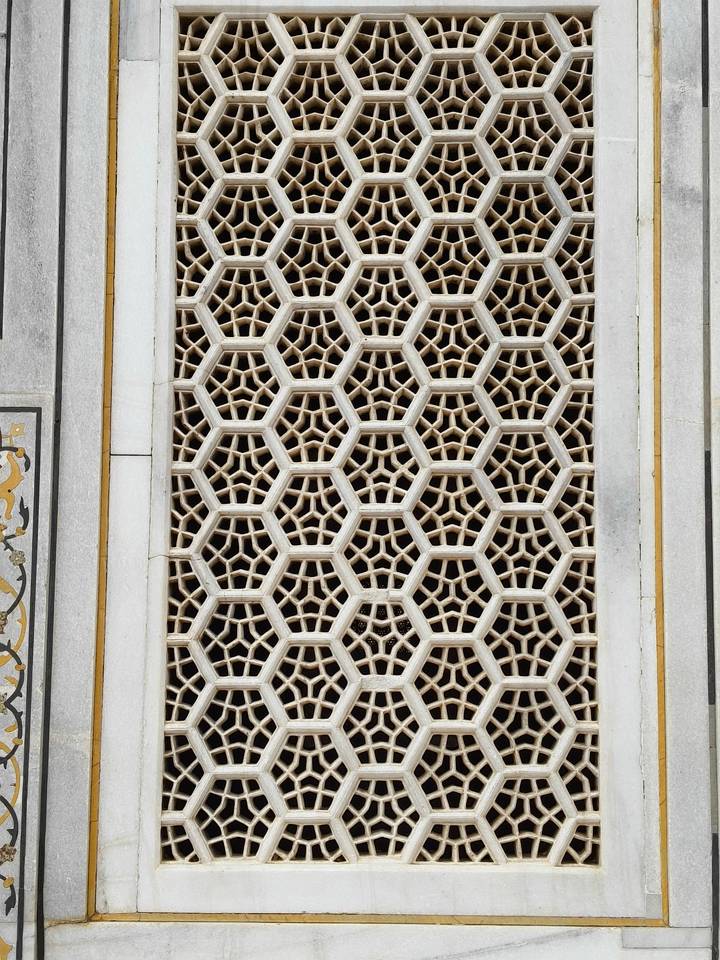 Detailed view of a geometric honeycomb marble screen showcasing fine Indian stone lattice work.
