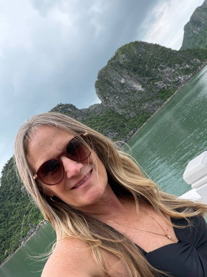 Selfie with limestone karsts and emerald water of Halong Bay in the background.