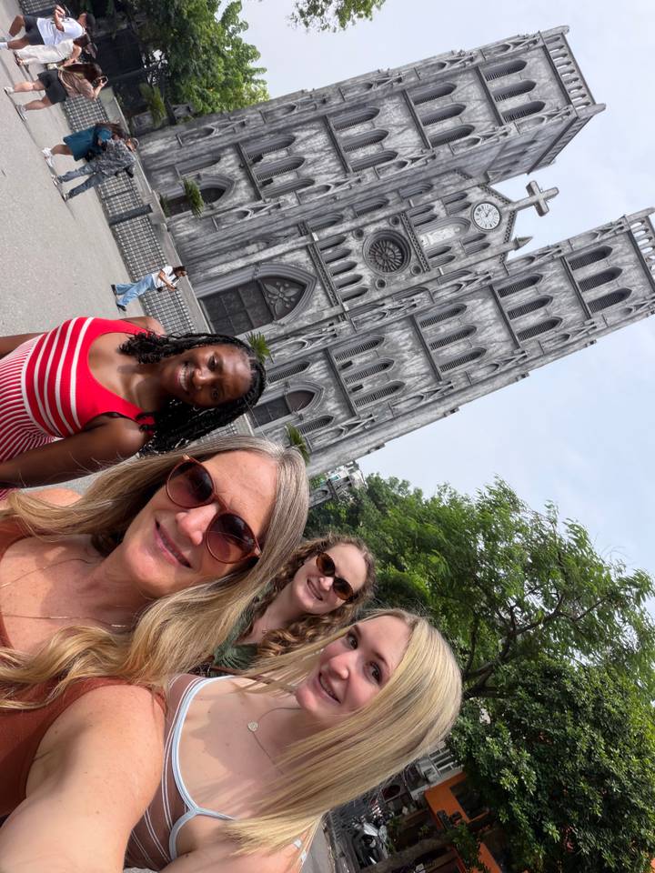 Three friends take a selfie in front of the Gothic St. Joseph’s Cathedral in Hanoi.
