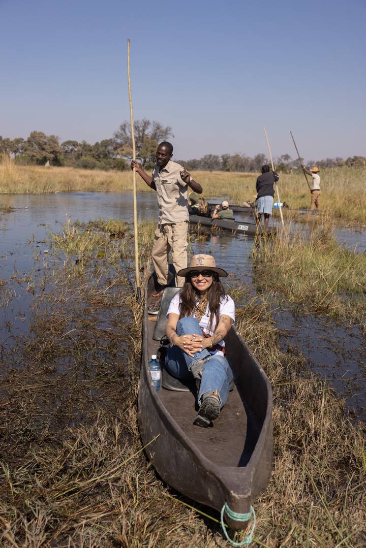 Traveller seated in a traditional mokoro canoe gliding through the marshy channels of the Okavango Delta.