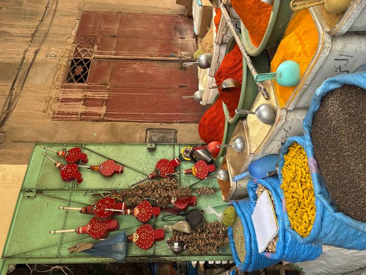 Vibrant spice market stall in Fes medina with mounds of turmeric, paprika and pepper.