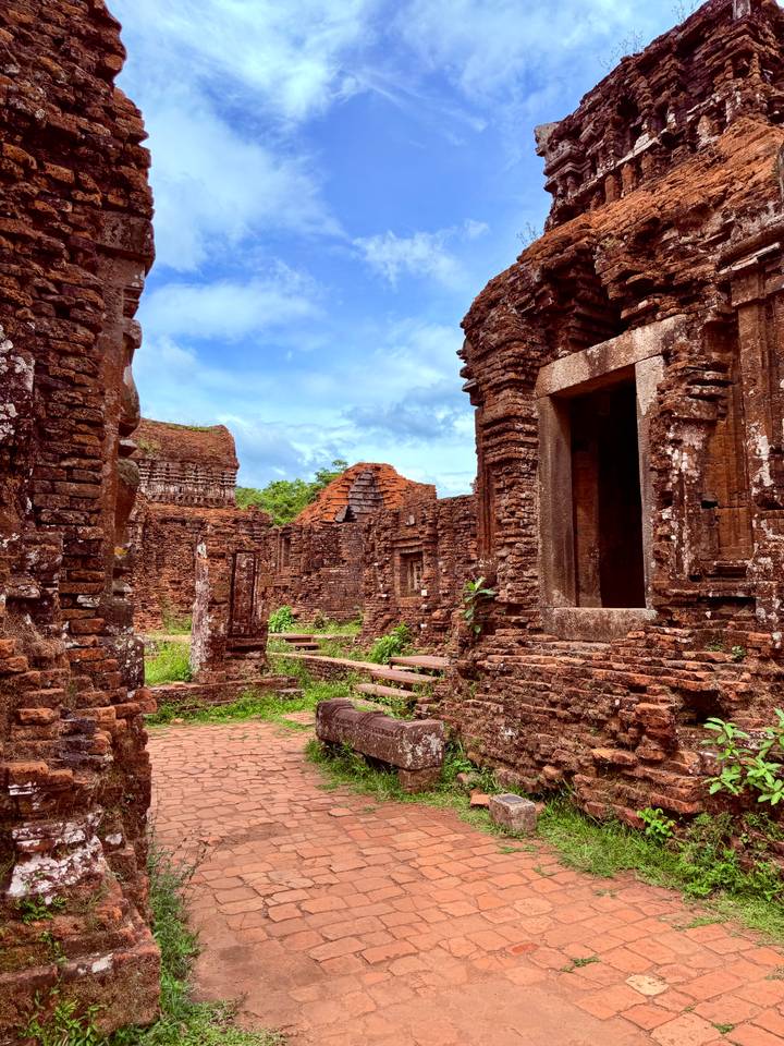 Ancient red-brick temple ruins surrounded by greenery at My Son Sanctuary.