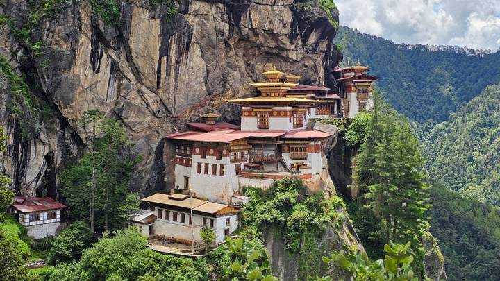 The iconic Tiger's Nest Monastery clings to a sheer cliff surrounded by lush green forest