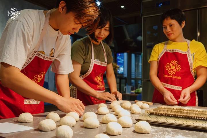 Young participants roll balls of dough during a Vietnamese cooking class.