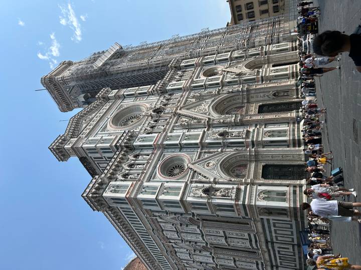 Imposing façade of Florence Cathedral and Giotto’s Campanile towering over tourists in the piazza.