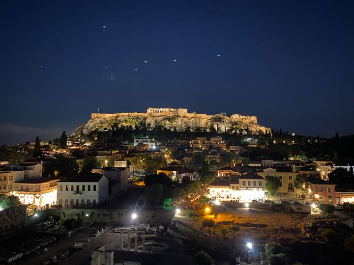 Night panorama of the illuminated Acropolis hill above Athens rooftops
