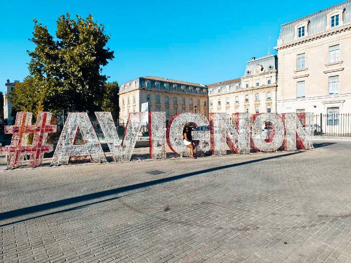 Large decorative #AVIGNON letters in a plaza with historic buildings in the background