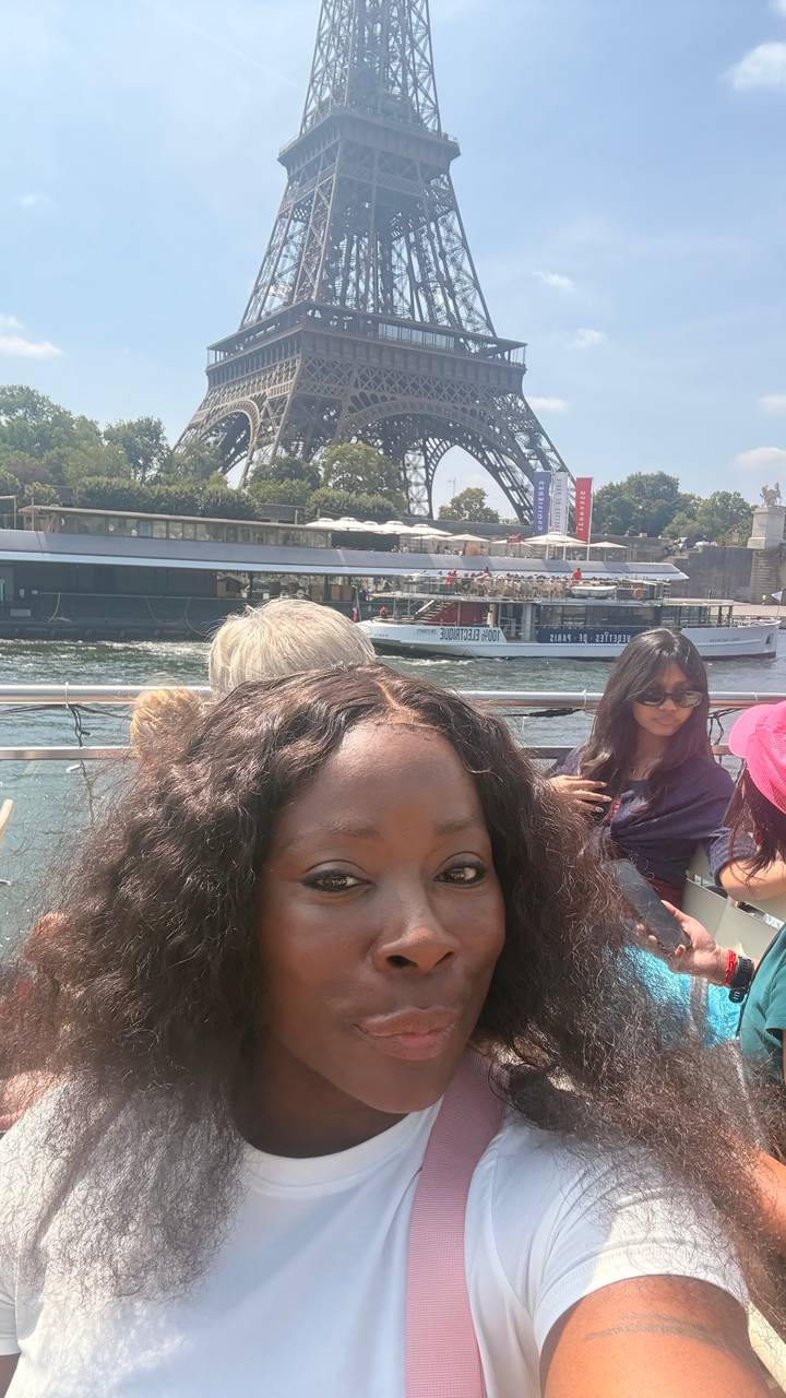 Selfie on a river cruise boat with other passengers and a passing vessel on the Seine.