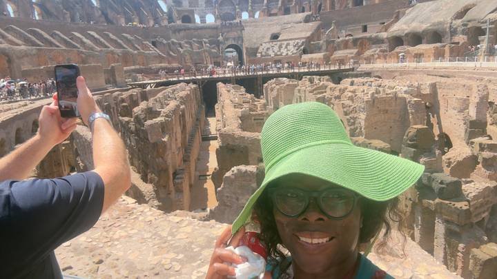 Traveler in a green sunhat takes a selfie inside the ancient ruins of the Colosseum.