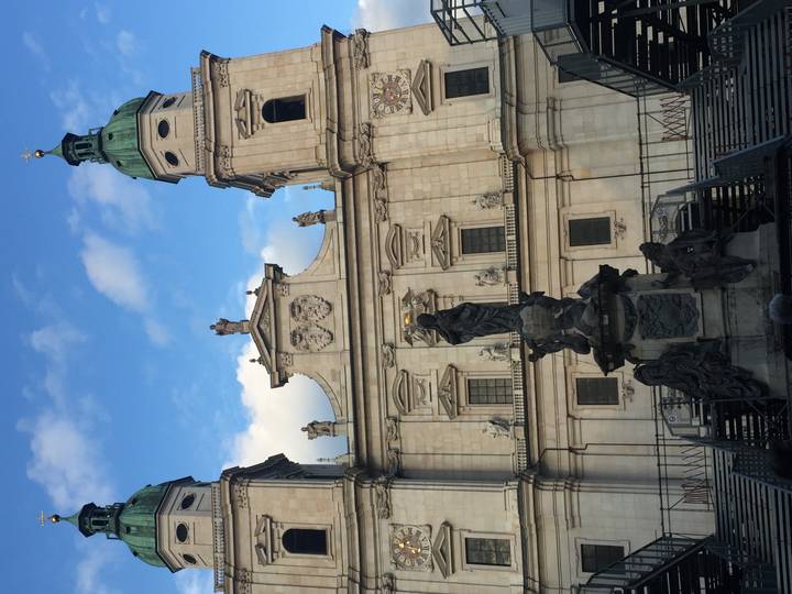 Facade of Salzburg Cathedral with statues and evening blue sky behind