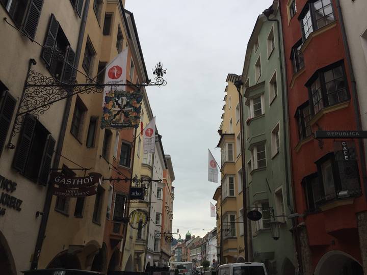 Narrow pedestrian street in Innsbruck Old Town with colourful facades and wrought-iron signs
