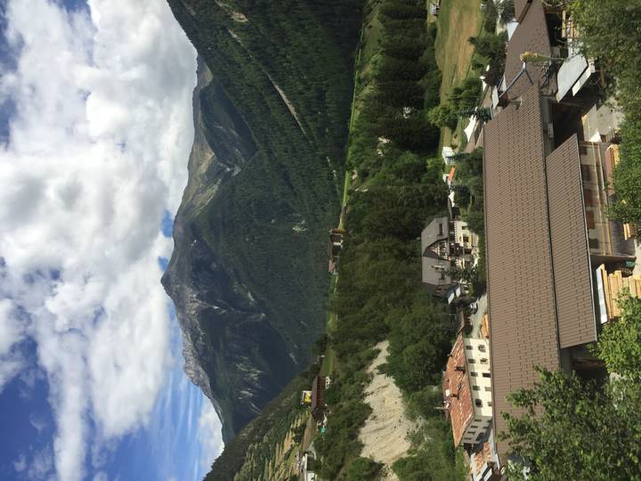 Mountain village with chalet roofs beneath dramatic ridges and patchy clouds