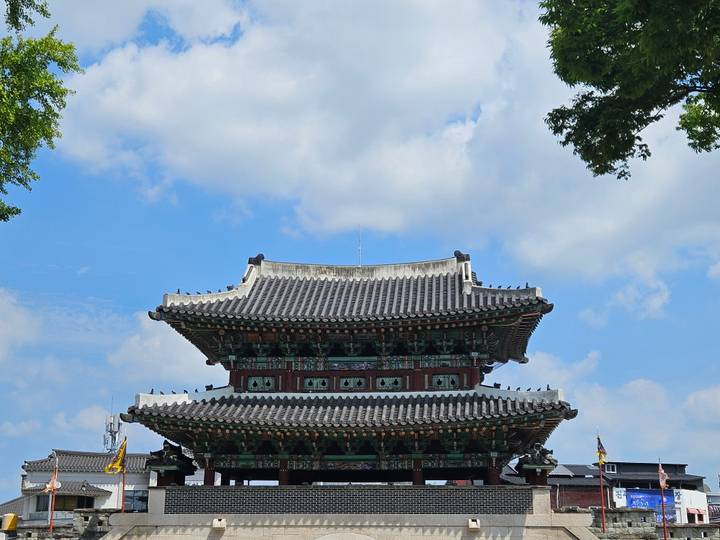 Close-up of a traditional Korean temple roof set against a bright blue sky.