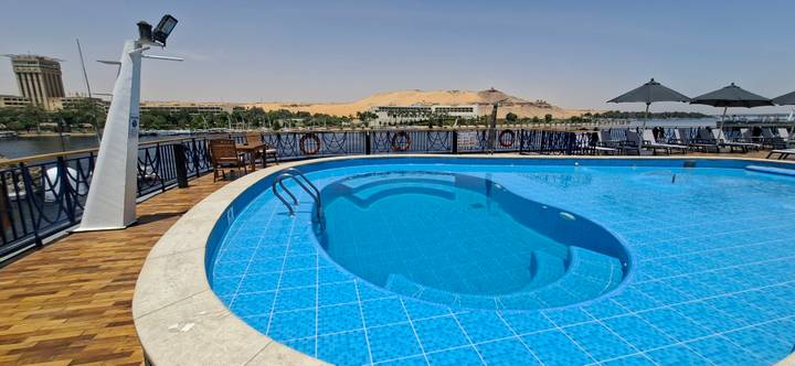 Sparkling blue swimming pool on the deck of a Nile cruise ship with desert backdrop.