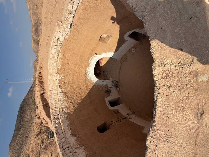 Sunken circular courtyard of a traditional underground Berber dwelling carved into desert earth near Matmata.