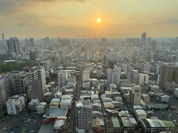 Sunset over Kaohsiung city skyline viewed from high vantage with golden haze.