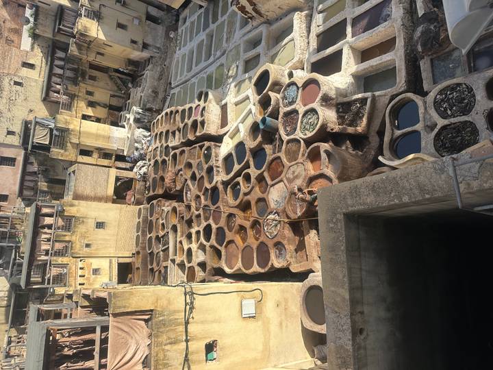 Elevated view of the Chouara leather tanneries with numerous circular dye pits in shades of brown and red.