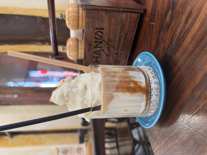 Glass of Vietnamese egg coffee topped with creamy foam at The Hanoi Cafe.