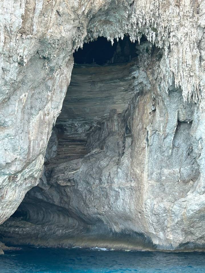 Dark rocky cave interior with rough stone stairs leading into shadowy depths.