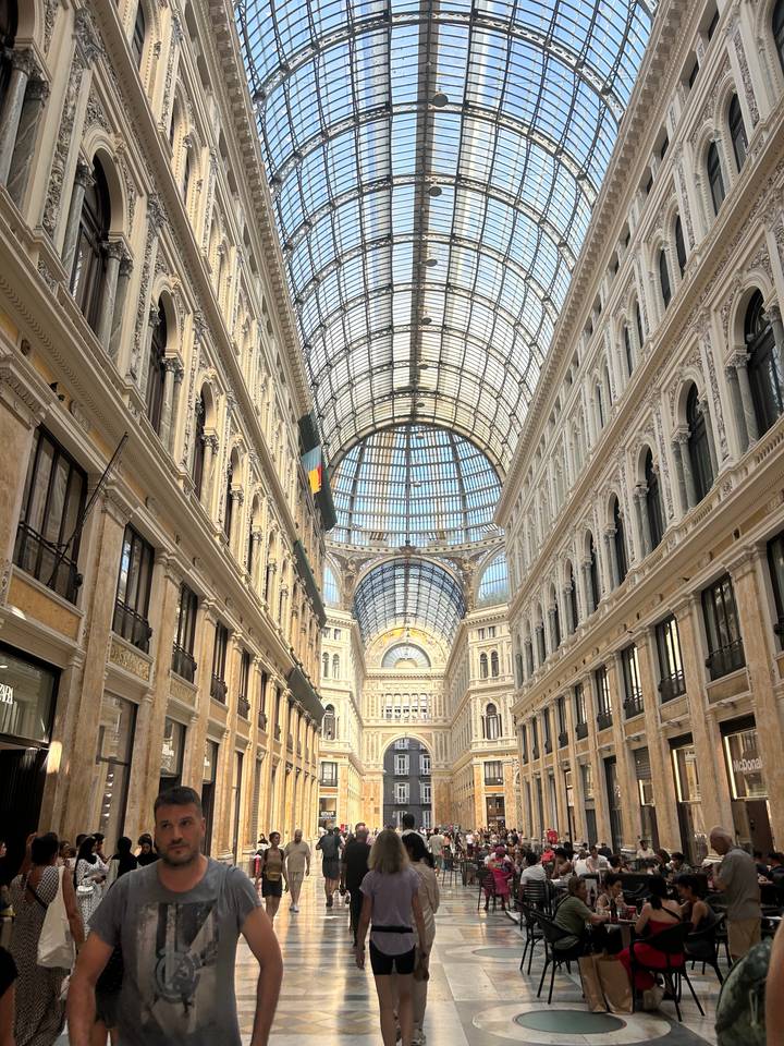 Elegant glass-roofed arcade with ornate architecture and long perspective in Naples.