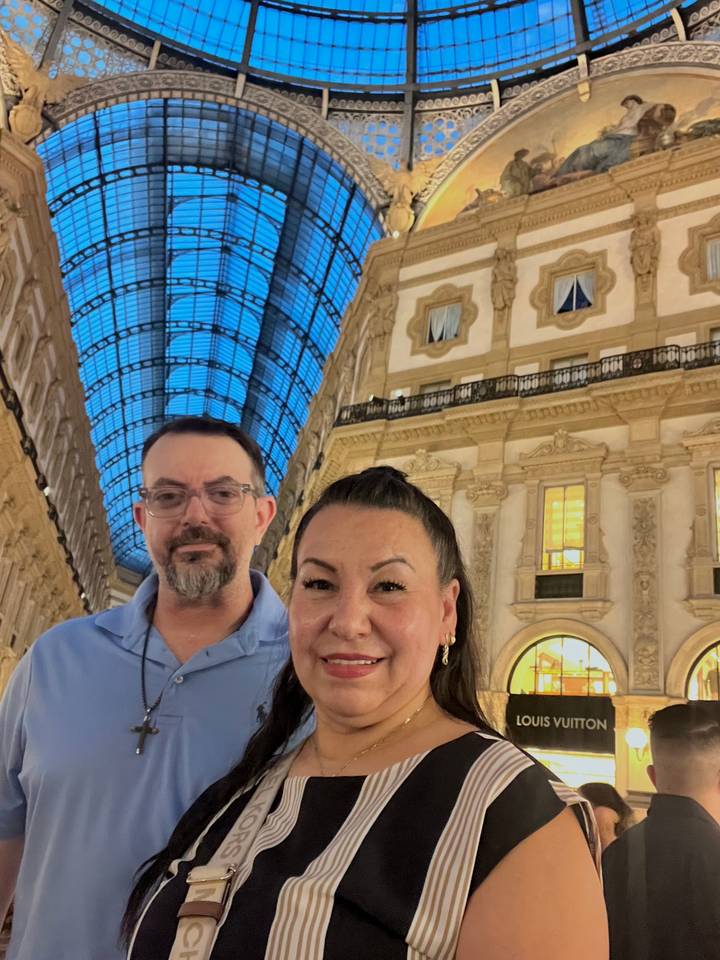 Couple smiling inside the grand Galleria Vittorio Emanuele II with glass dome overhead