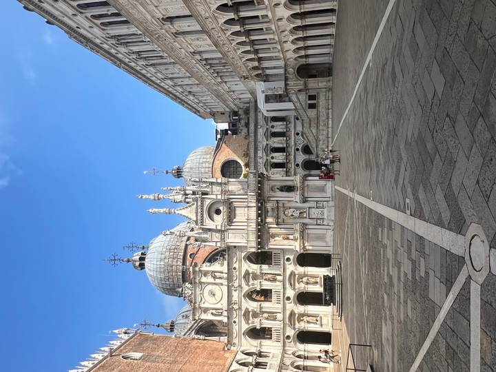 Wide shot of Doge's Palace courtyard with domes, arches and empty stone square