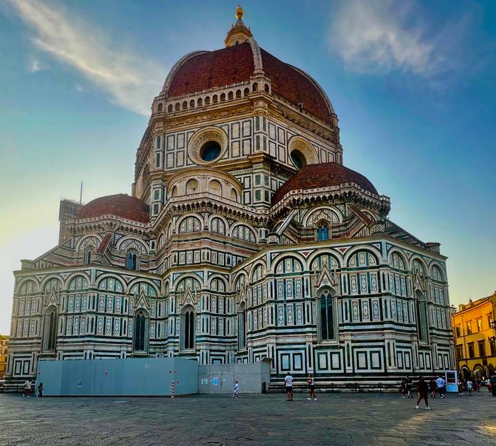 Florence Cathedral illuminated by warm evening light against clear sky