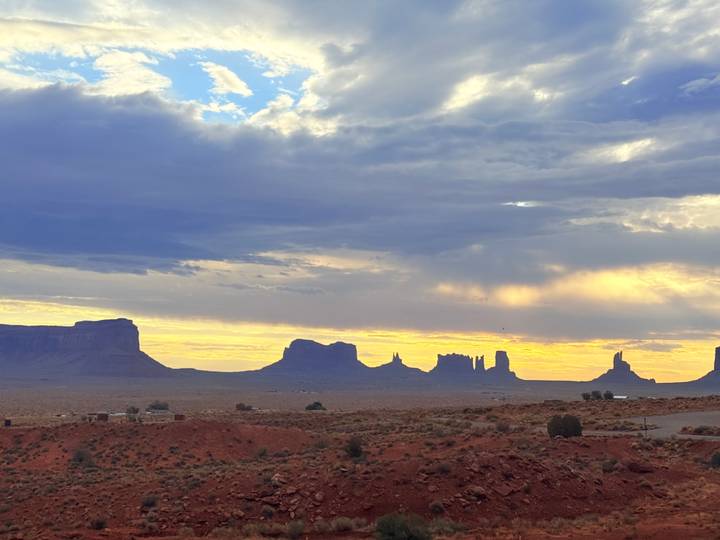 Silhouettes of Monument Valley buttes under a colorful evening sky