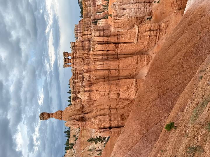 Red hoodoo rock formations and balanced pillars beneath a moody sky