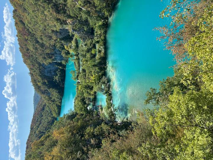 Vibrant turquoise cascades and lush greenery of Plitvice Lakes from an elevated viewpoint.