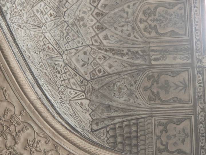 Intricate Mughal interior ceiling with floral and geometric stucco patterns.