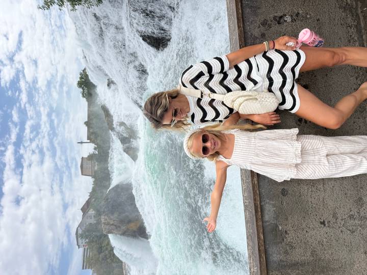 Mother and daughter posing with Rhine Falls thundering in the background