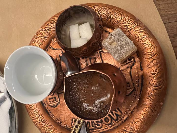 Traditional Bosnian coffee set on ornate copper tray with sugar cubes and lokum sweet