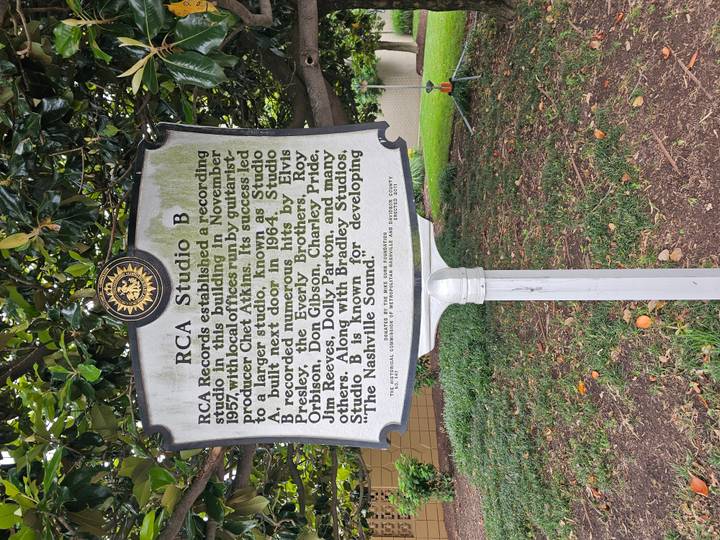 White roadside marker describing the history of RCA Studio B under leafy branches