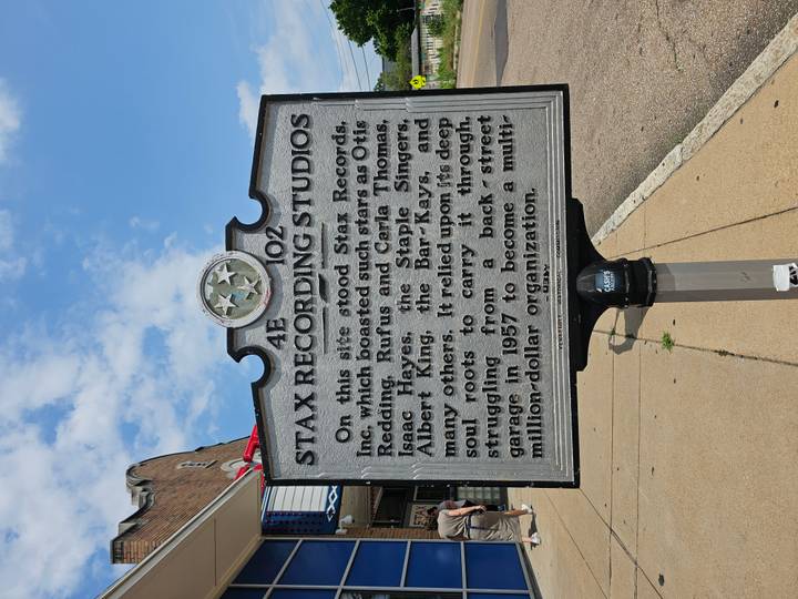 Grey historical marker for Stax Recording Studios on a sunny street corner