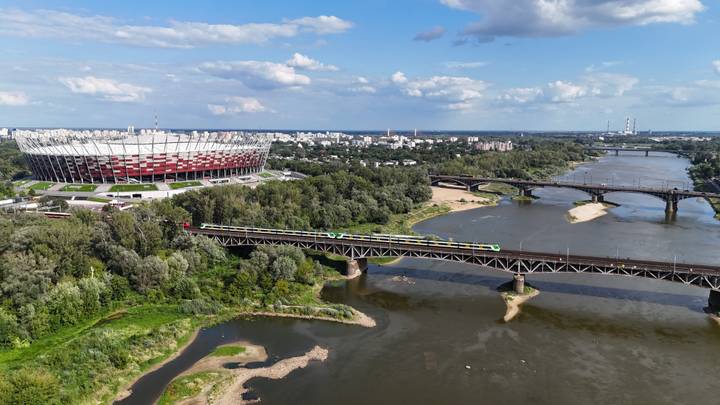aerial view of Warsaw National Stadium beside the Vistula River and multiple bridges