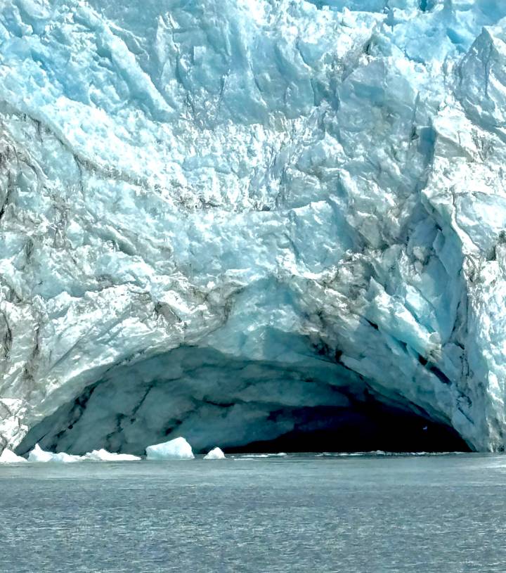 close-up texture of blue glacial ice with crevasses and crystalline patterns