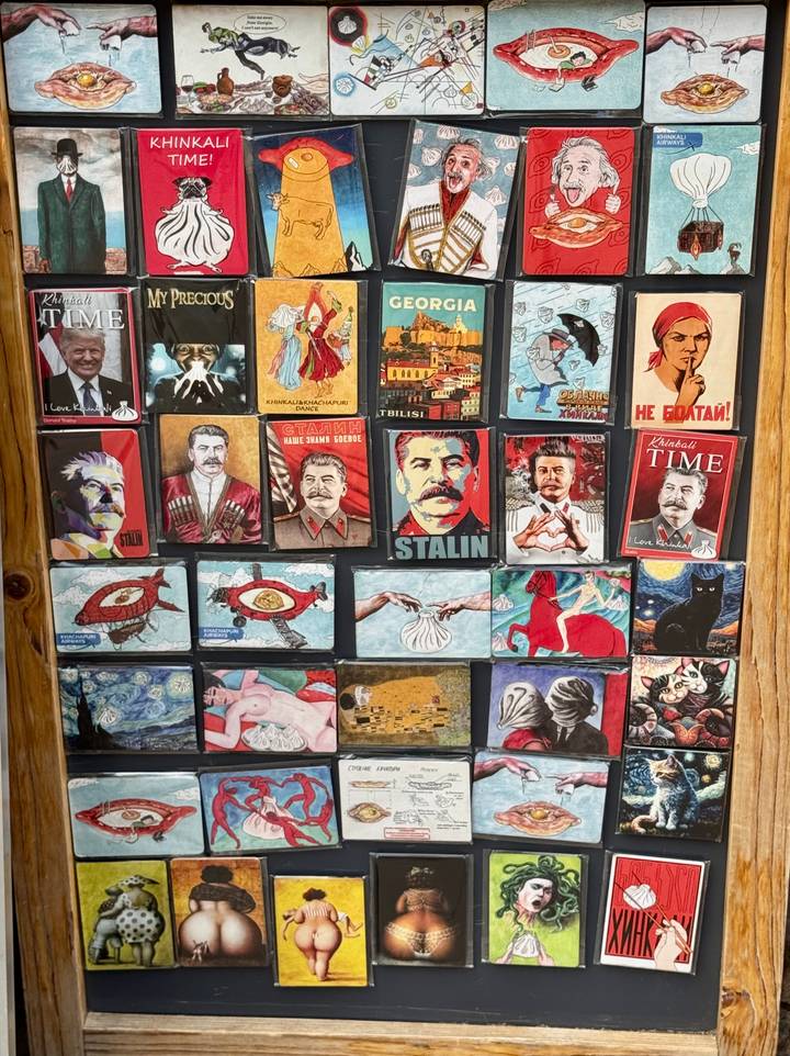 Display board filled with colourful souvenir magnets depicting Soviet imagery and Georgian themes