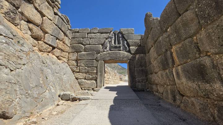 The famous Lion Gate entrance at Mycenae framed by massive stone walls under a clear sky.
