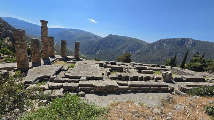 Stone foundations and standing columns of the Temple of Apollo overlook a mountain valley at Delphi.