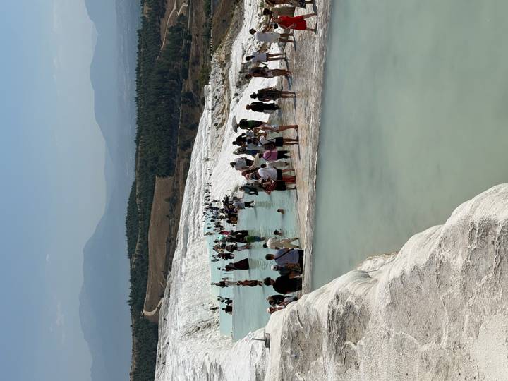 Dozens of visitors wade through the turquoise thermal pools of Pamukkale’s travertine terraces.