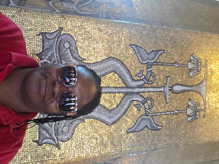 Selfie in front of a detailed golden mosaic artwork inside an ornate hall.