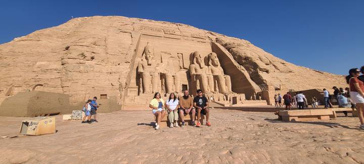 Group portrait in front of the colossal statues of Abu Simbel under clear blue sky