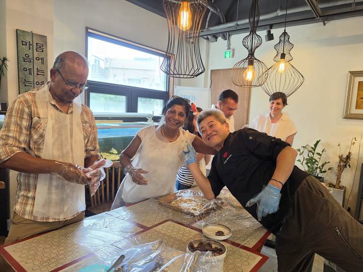 Participants laugh together during a hands-on cooking class in a bright kitchen