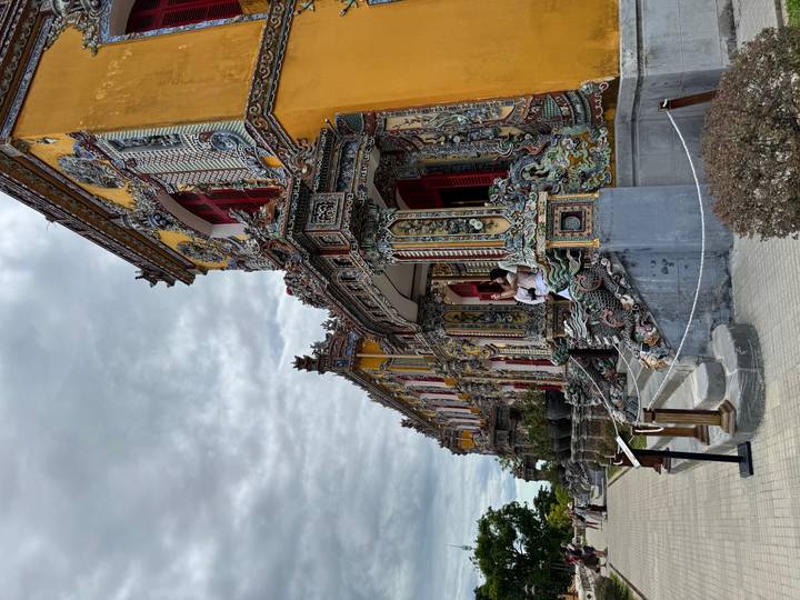 Vibrant yellow and red building of the Hue Imperial Palace richly decorated with dragon motifs.