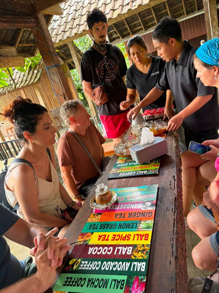 Travelers sample assorted Bali coffees and teas at a rustic tasting table.