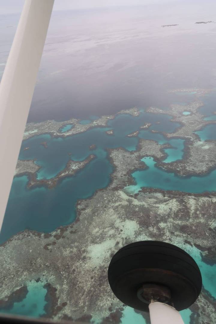 Aerial view of turquoise lagoons and intricate coral formations surrounded by deeper blue water.