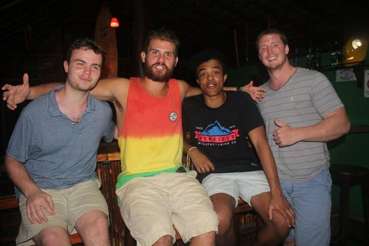 Four friends posing for a photo in casual clothing.